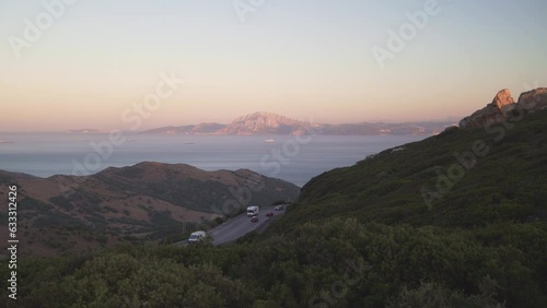 Strait of Gibraltar strait view from Spain with Jebel Musa mountain road with campers and cars and big transport ships crossing from mediterranean to atlantic ocean
