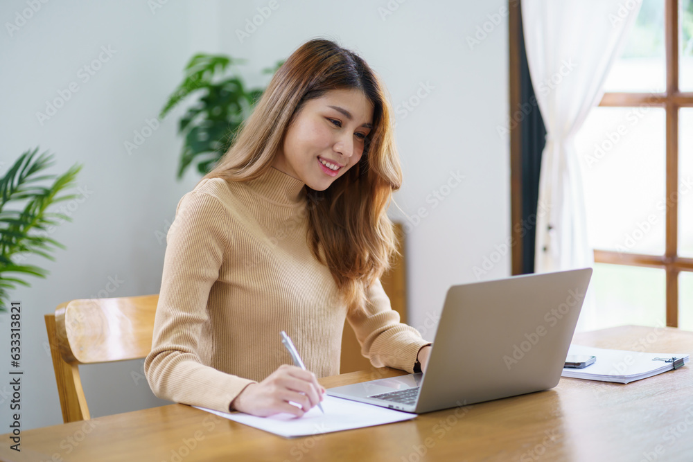 Obraz premium Happy beautiful Asian woman using computer laptop for work online at living room.