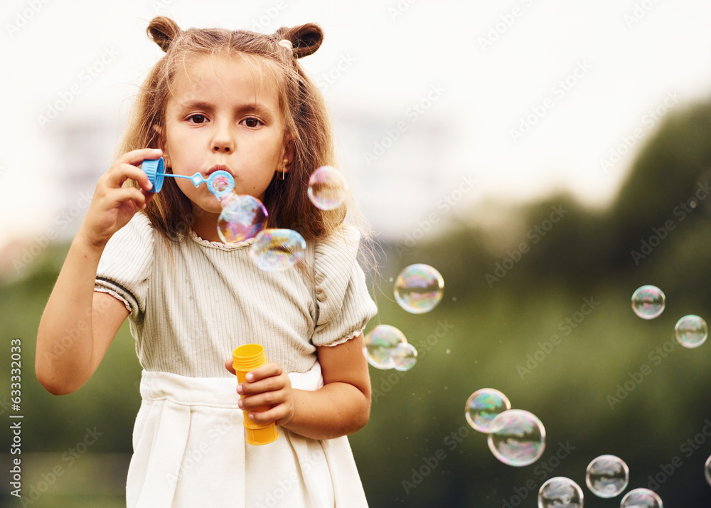 Portrait of little girl that is playing with bubbles outdoors Portrait of little girl that is playing with bubbles outdoors