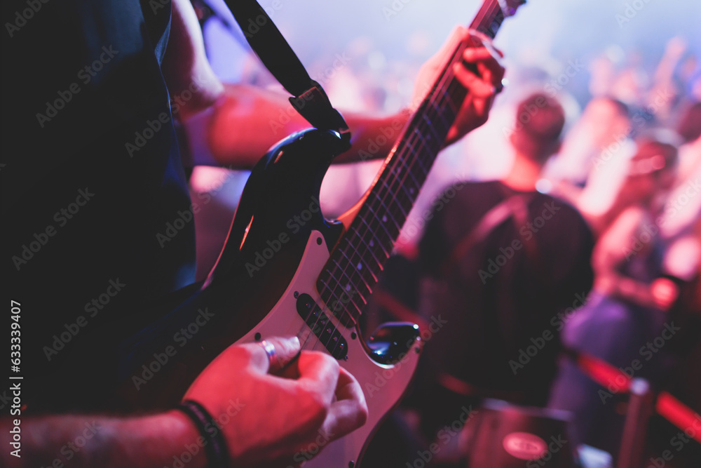 Φωτογραφία Concert view of an electric guitar player with vocalist and rock band performing
