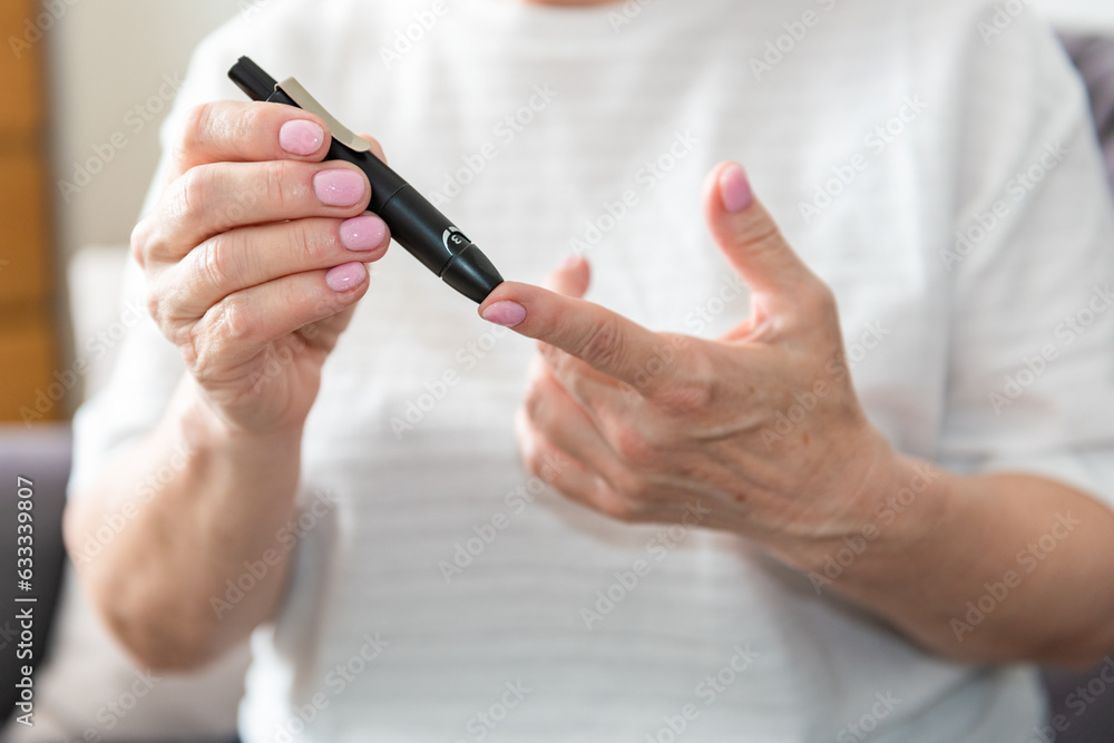 Old woman hands using lancet on finger to check blood sugar level, diabetes concept, health care Old woman hands using lancet on finger to check blood sugar level, diabetes concept, health care