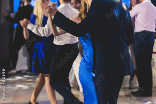 High school graduates dancing waltz and classical ball dance in dresses and suits on school prom graduation, classical ballroom dancers dancing, waltz, couples quadrille and polonaise
