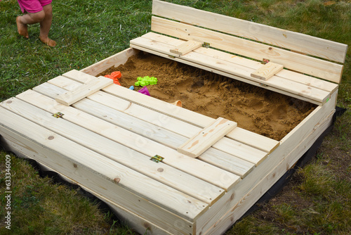 Homemade children´s sandbox, playground with a sand in the garden. Childhood concept. Europe, Czech Republic.