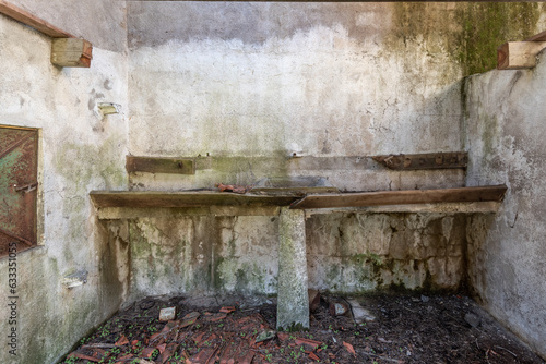 Wall of an abandoned dilapidated house with a broken water sink