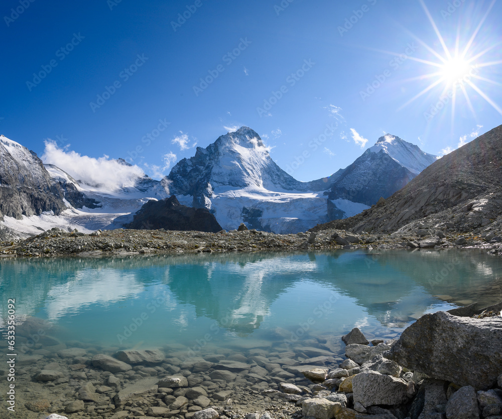 Dent Blanche with sunstar mirroring in an glacier lake