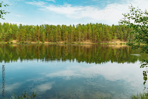 beautiful sunset at forest lake. Pine forest and sky reflecting in water