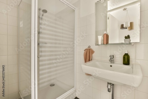 a bathroom with a sink  mirror and towel rack on the wall next to it is a glass shower door