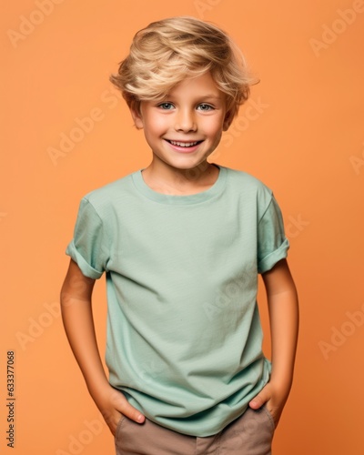 Little pretty boy smiling model posing at camera in bright studio