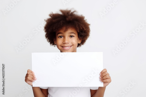 Happy black scholl boy holding blank white banner sign, isolated studio portrait. photo