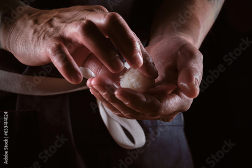 Male shushi man hands preparing different pieces of makis