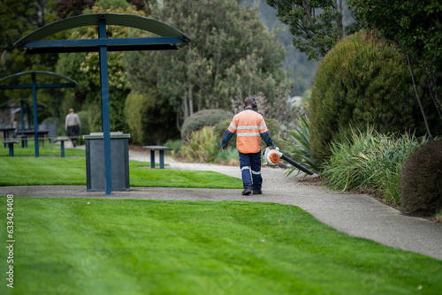 Фотография council worker with a leaf blower in a park