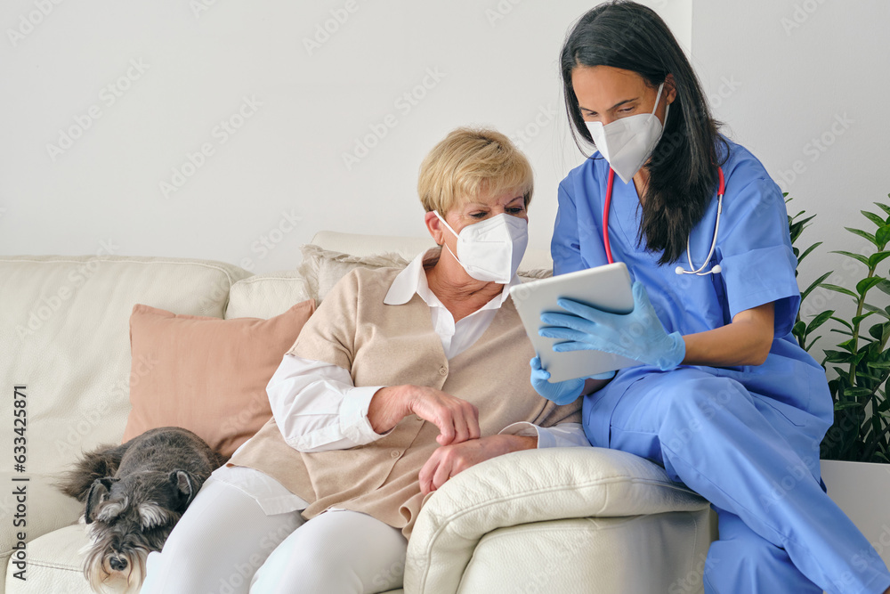 Obraz premium Doctor sharing tablet with elderly patient during examination in