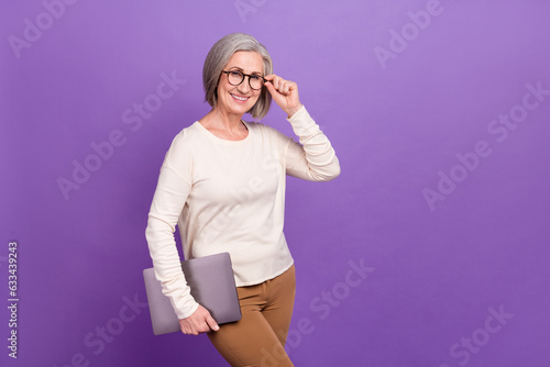 Photo of attractive old woman trendy gucci eyeglasses watch you hold laptop control quality online isolated over violet color background