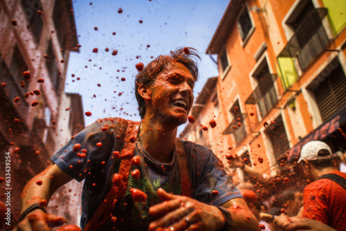 People enjoy the unique atmosphere La Tomatina festival. Young people happily throw tomatoes. Traditional spirited celebration at Tomatina festival in Bunol, located in the Valencia region of Spain © vejaa