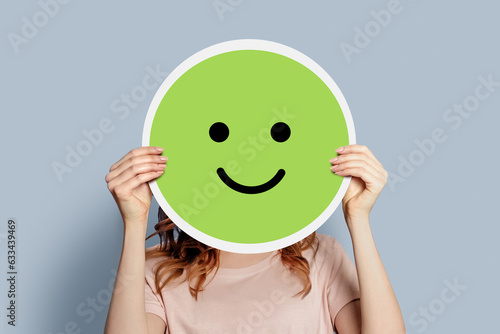 Girl holding a paper poster with a happy cheerful smiley