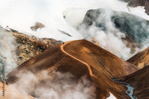 Kerlingarfjoll mountain range with a man walking on trail and smoke during summer at Iceland photo