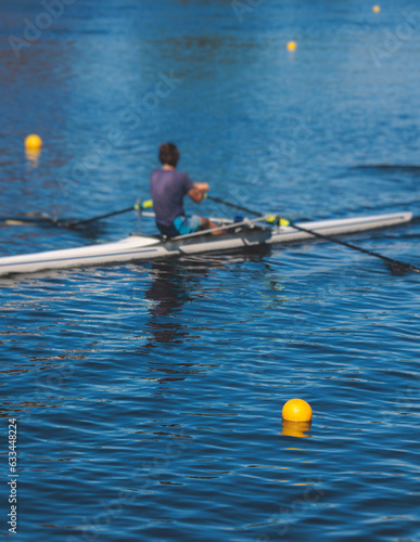 Group of rowing team athletes sculling during competition, kayak boats race in a rowing canal, regatta in a summer sunny day, canoeing water sports team training in a river photo