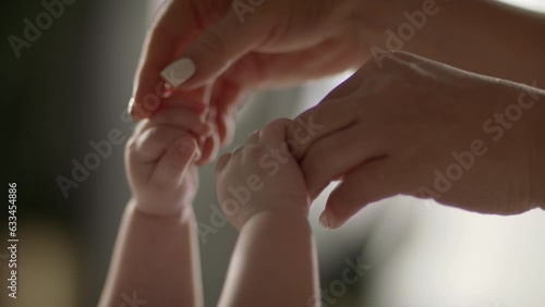 Mother and newborn baby in maternity home. Hand in hand. Parenthood. 