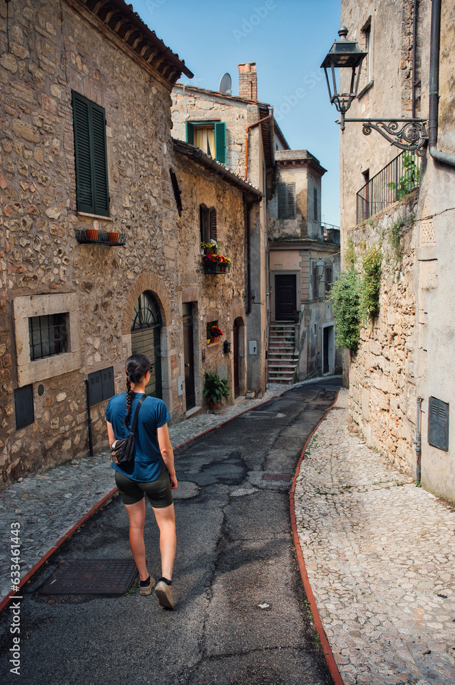 Frau spaziert durch eine historische Altstadt in Italien