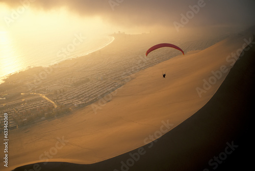 Paraglider over El Dragon, a large sand dune near Iquique, Chile at the edge of the Atacama Desert; Chile photo