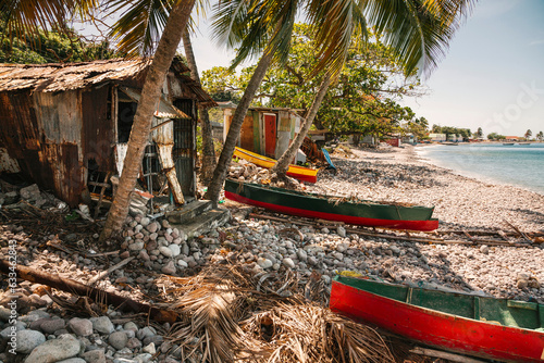 Tableau sur toile Fishing huts and traditional dugout fishing boats beached along the shore of the