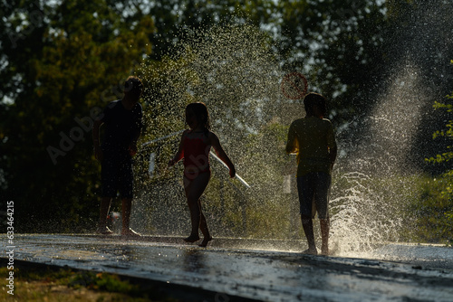 Children playing water in scorching weather in a park.