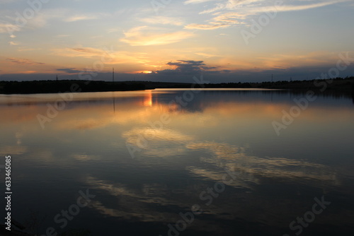 A body of water with a sunset in the background