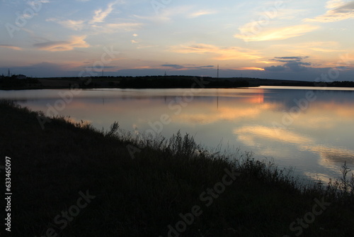 A body of water with grass and trees in the background © parpalac