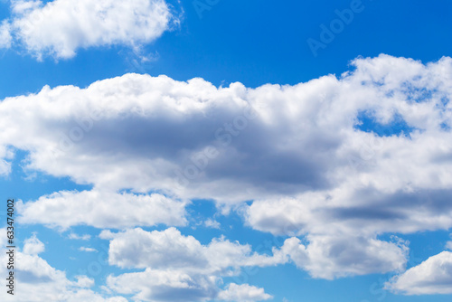 Fluffy white clouds in clear blue sky. Beautiful natural background for your design
