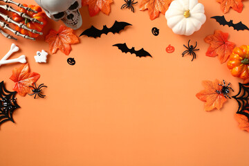 Happy Halloween holiday concept. Halloween decorations, spiders, pumpkins, bats, ghosts, maple leaves on orange background. Flat lay, top view, copy space.