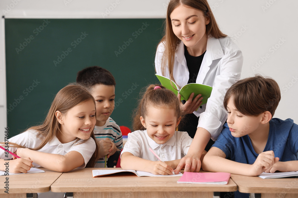 Little pupils having lesson with teacher in classroom Little pupils having lesson with teacher in classroom