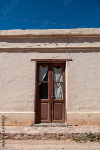 Quaint old door with windows built into an old mud house. Town in the north of Argentina. (ID: 633479638)
