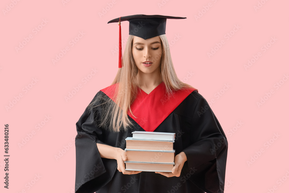 Female graduate student with books on pink background Female graduate student with books on pink background