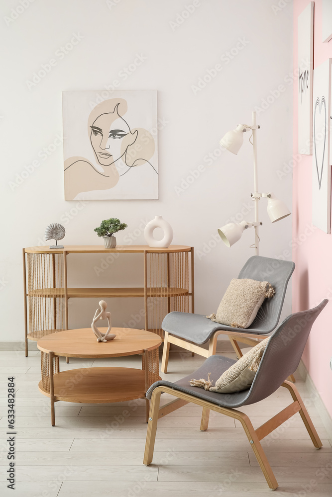 Interior of living room with cozy grey armchairs, coffee table, shelving unit and beautiful painting Interior of living room with cozy grey armchairs, coffee table, shelving unit and beautiful painting