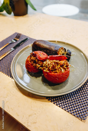 presentation of a lunch plate with cooked vegetables with rice, tomatoes and cooked aubergine.