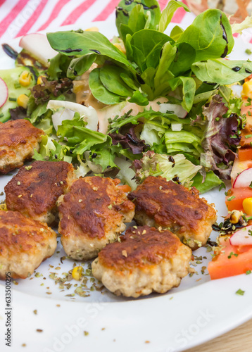 Traditional german small meatballs (frikadelle) served with salad and tomato