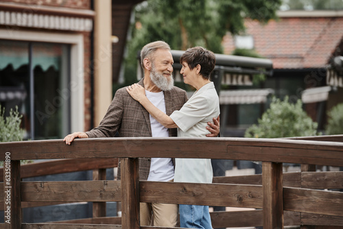 romantic senior couple standing together on wooden bridge and hugging each other, elderly love, bond © LIGHTFIELD STUDIOS