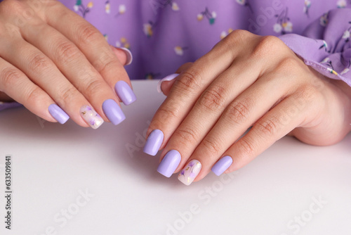 Beautiful female hands with purple manicure nails  flower design