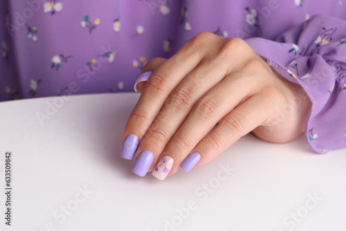 Beautiful female hand with purple manicure nails  flower design