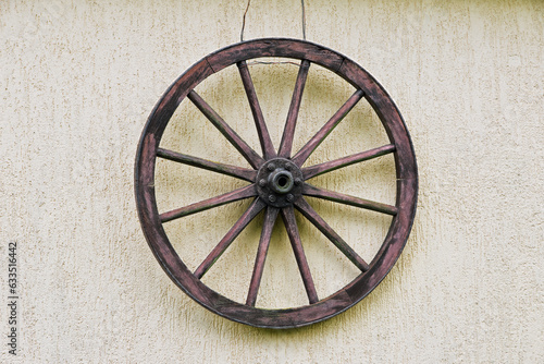 vintage vehicle wheel made of wood with iron rim and bearing hanging on the wall