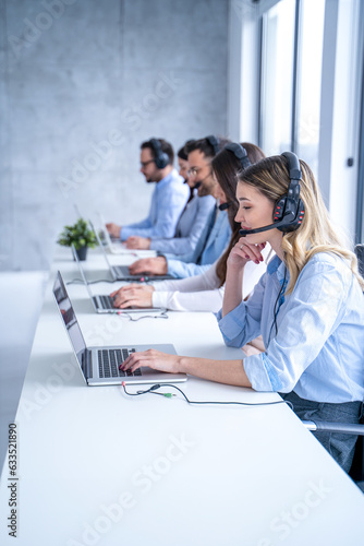 Smiling blond haired customer support agent woman listening attentively to the client's inquiries, demonstrating her dedication to providing top-notch service.