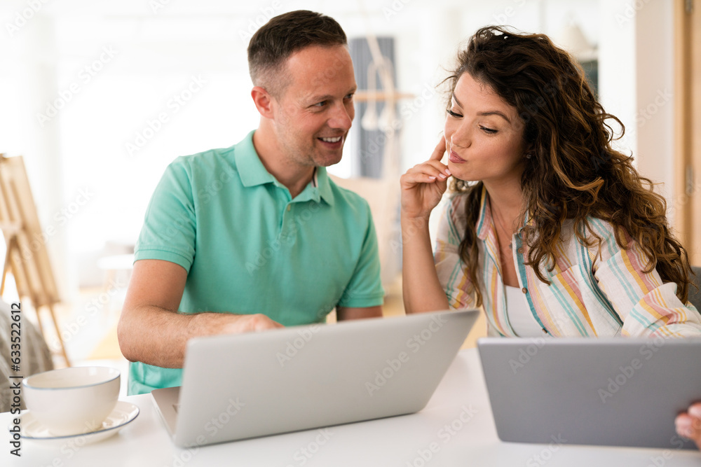 Playful young loving couple where wife is looking at laptop and husband is looking at woman while surfing the net. Playful young loving couple where wife is looking at laptop and husband is looking at woman while surfing the net.