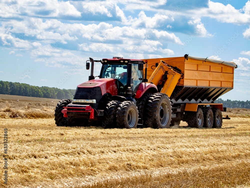 Obraz premium Tractor with grain cart working on a field