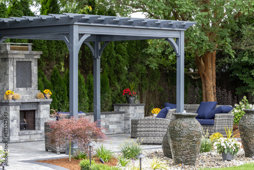 Landscape architecture featuring pergola and stone fireplace with stone urn water fountains