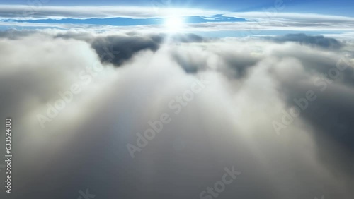 (Seamless loop) Flying through majectic clouds with the sun shining on the horizon. Dreaming of heavens and tranquility with rays of light and sunbeam