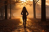 Jogger running through a park early in the morning - stock photography