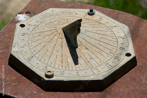 Old metal sundial with clear light showing the time in the middle of the day © Sylvain