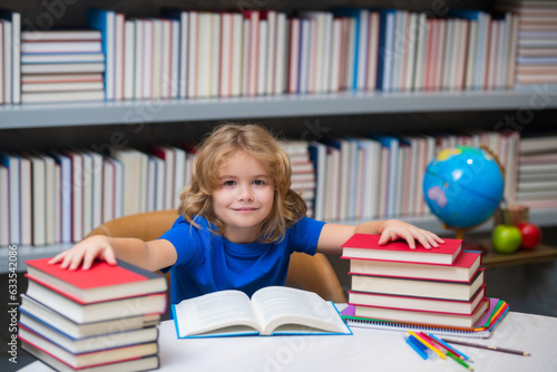 Pupil read book. Schoolboy reading book in library. Kids development, learn to read. Pupil reading books in a school library. School child doing homework, study hard.