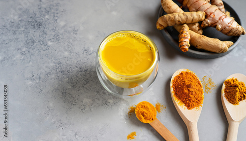 Ingredients for turmeric latte. Ground turmeric, curcuma root, cinnamon, ginger, black pepper on grey background. Spices for ayurvedic treatment. Alternative medicine concept.