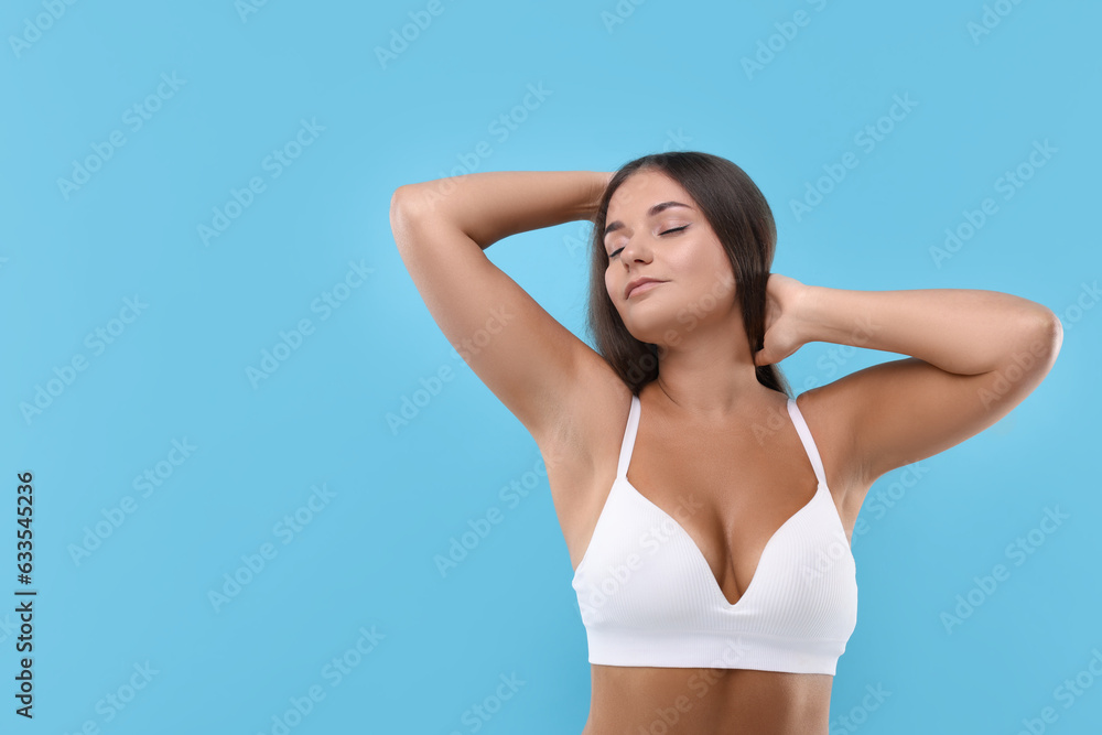 Portrait of young woman with beautiful breast on light blue background. Space for text Portrait of young woman with beautiful breast on light blue background. Space for text